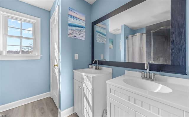 bathroom featuring walk in shower, vanity, and hardwood / wood-style floors