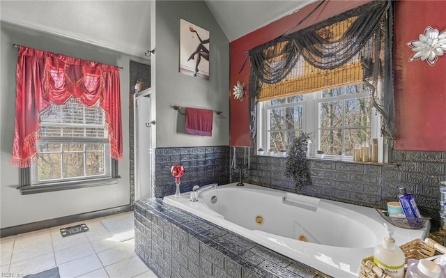 bathroom featuring tiled tub, vaulted ceiling, and tile patterned floors