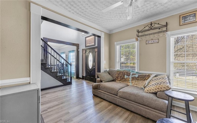 living room featuring crown molding, wood-type flooring, and a textured ceiling