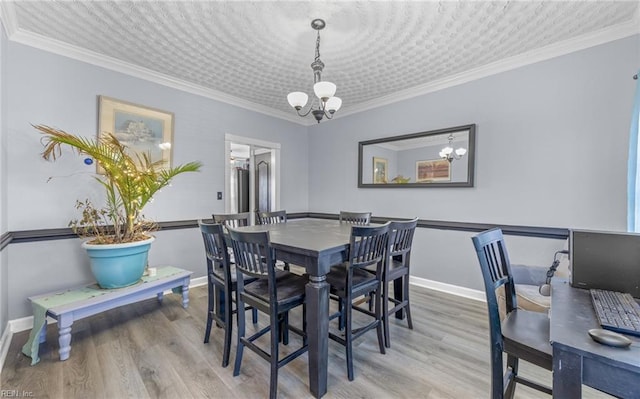 dining area featuring ornamental molding, a chandelier, and wood-type flooring