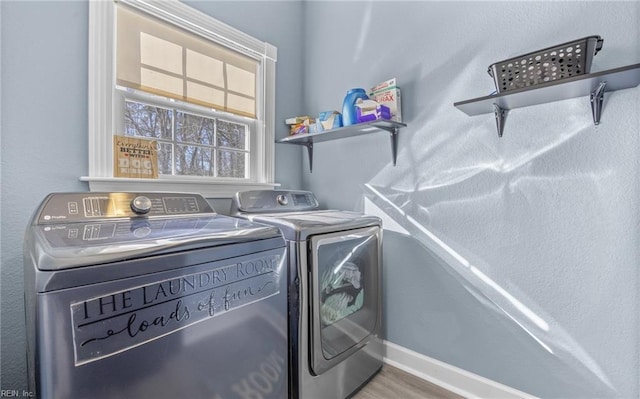 clothes washing area featuring washer and clothes dryer and wood-type flooring