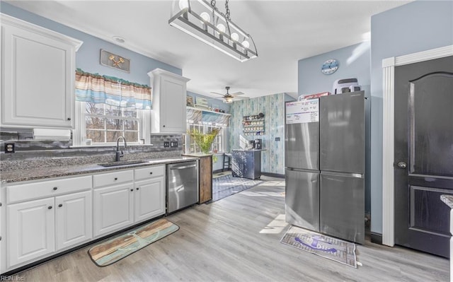 kitchen featuring stainless steel appliances, sink, light hardwood / wood-style flooring, and white cabinets