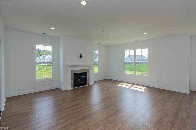 unfurnished living room with a healthy amount of sunlight and dark hardwood / wood-style floors