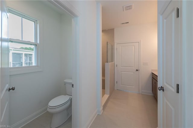 bathroom featuring vanity, a shower, and toilet