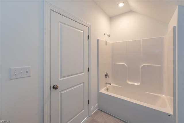 bathroom with lofted ceiling and bathing tub / shower combination