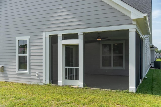 view of side of home featuring a lawn, a sunroom, and ceiling fan