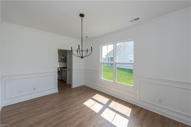 unfurnished dining area with crown molding, hardwood / wood-style flooring, and a chandelier