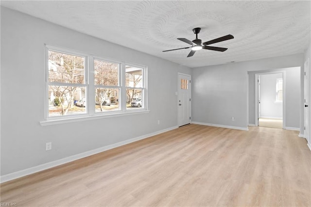 spare room featuring ceiling fan, light hardwood / wood-style flooring, and a textured ceiling