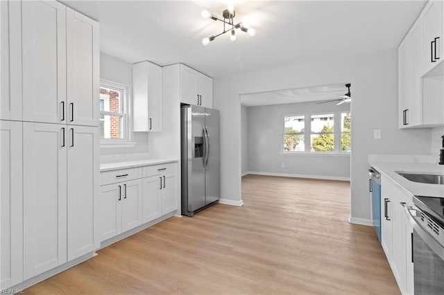 kitchen featuring sink, white cabinetry, light hardwood / wood-style flooring, appliances with stainless steel finishes, and ceiling fan