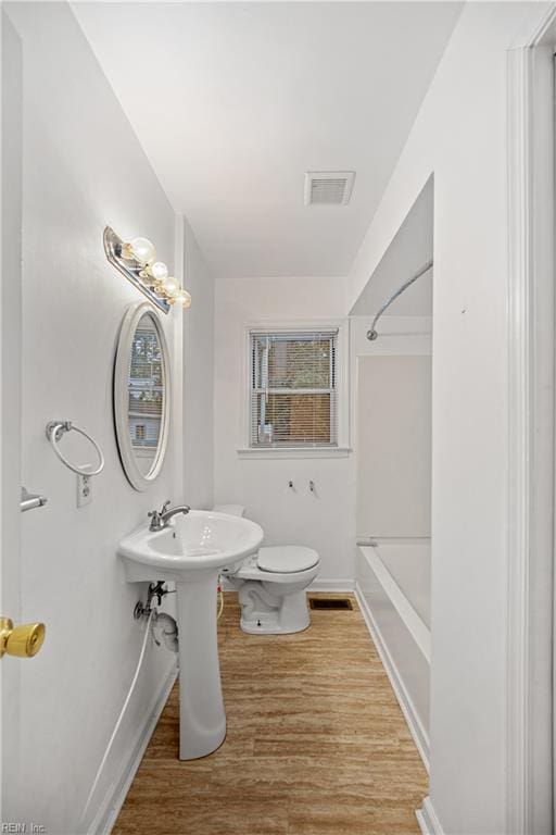 bathroom with wood-type flooring and toilet