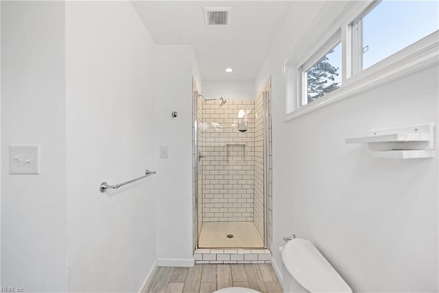 bathroom with toilet and a shower with door