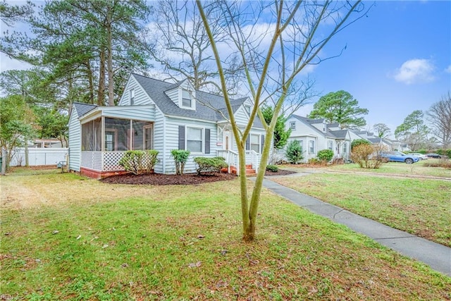 cape cod-style house with a sunroom and a front yard