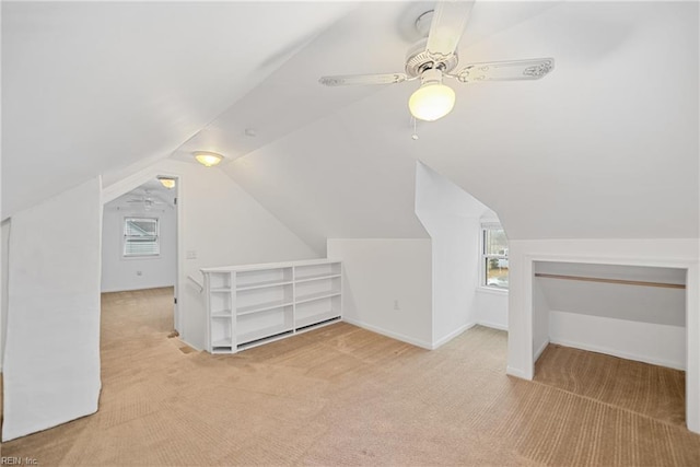 additional living space featuring light colored carpet, lofted ceiling, and a wealth of natural light