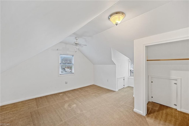 bonus room with vaulted ceiling, light colored carpet, and ceiling fan