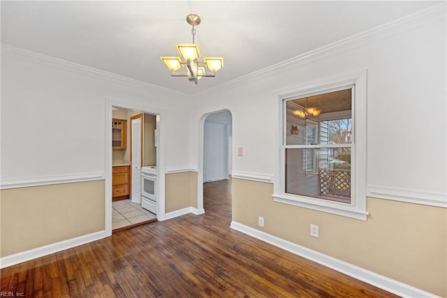 unfurnished room with hardwood / wood-style flooring, crown molding, and a notable chandelier