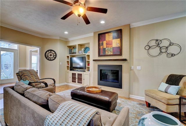 living room with ceiling fan, ornamental molding, built in features, and a textured ceiling