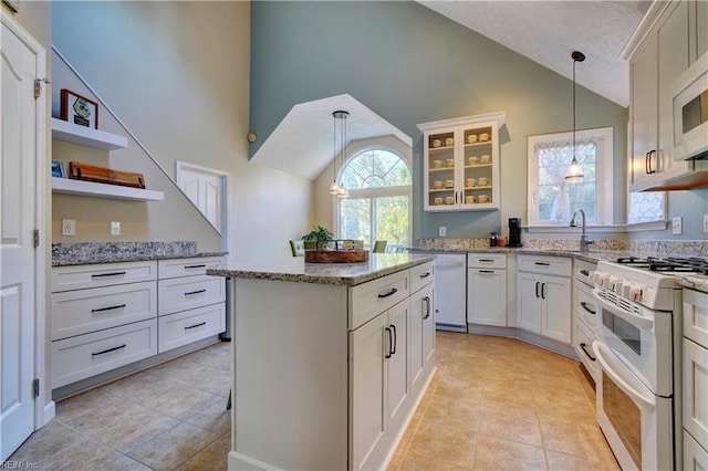 kitchen featuring a kitchen island, white cabinets, hanging light fixtures, light stone countertops, and white appliances