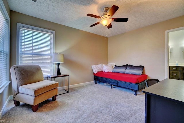 carpeted bedroom with ceiling fan, a textured ceiling, and ensuite bath