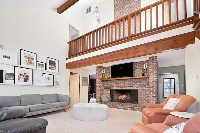 carpeted living room with beamed ceiling, a brick fireplace, and a high ceiling