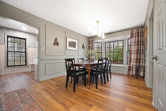 dining area featuring ornamental molding, a notable chandelier, and light hardwood / wood-style flooring