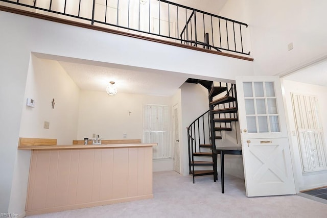 kitchen featuring a high ceiling and light colored carpet