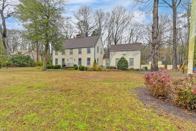 colonial inspired home featuring a front lawn