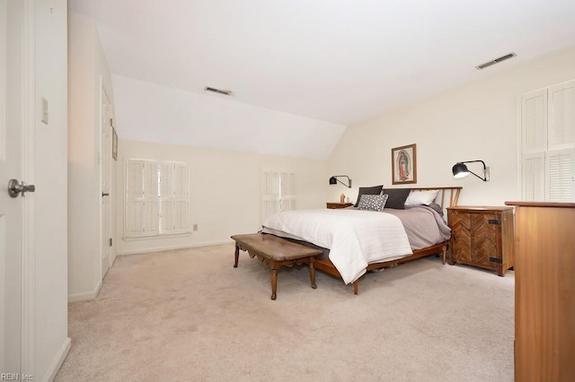 bedroom featuring light carpet and vaulted ceiling