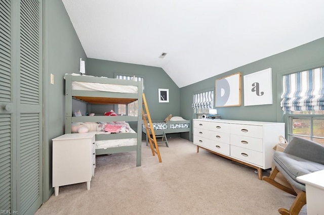 bedroom featuring lofted ceiling, multiple windows, light colored carpet, and a closet