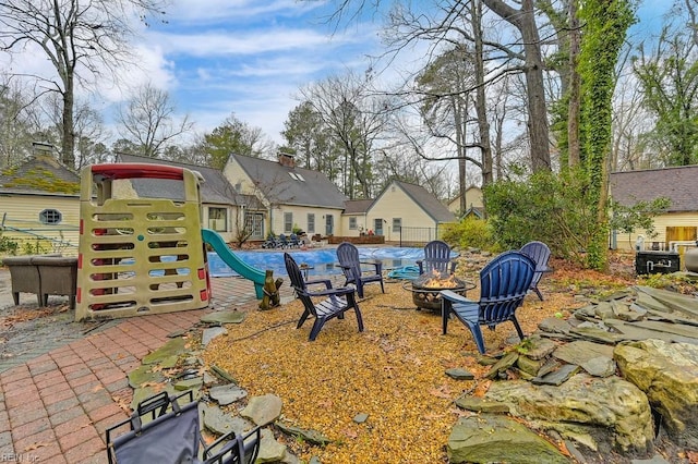 exterior space with an outdoor fire pit and a playground