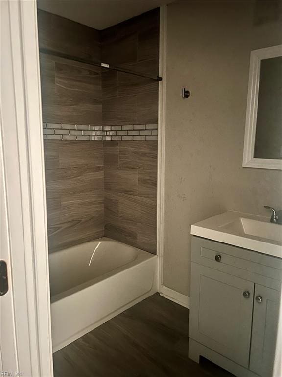 bathroom featuring tiled shower / bath combo, wood-type flooring, and vanity