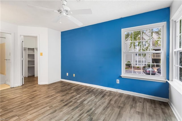 107 Marshall Way Unit J, Williamsburg, VA 23185 - unfurnished bedroom featuring wood finished floors, a walk in closet, a closet, baseboards, and a ceiling fan