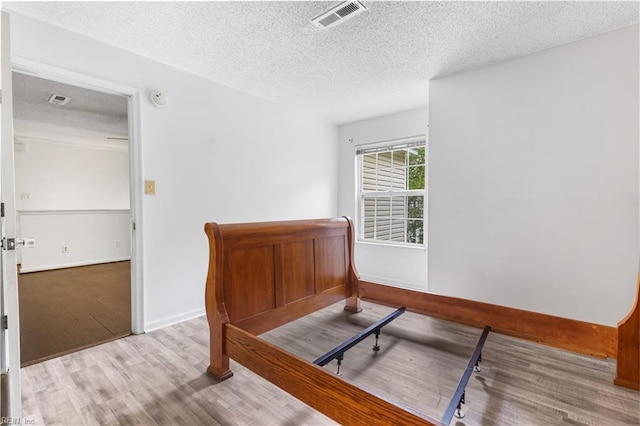 107 Marshall Way Unit J, Williamsburg, VA 23185 - bedroom with a textured ceiling, wood finished floors, and baseboards