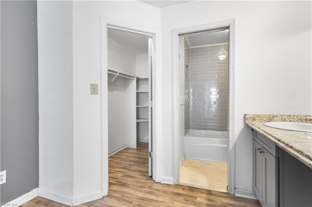 107 Marshall Way Unit J, Williamsburg, VA 23185 - bathroom featuring vanity, wood finished floors, a spacious closet,  shower combination, and baseboards