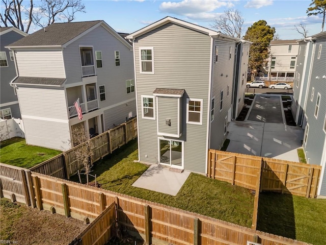 back of property featuring a patio and a lawn