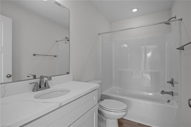 full bathroom with vanity, tub / shower combination, hardwood / wood-style floors, and toilet