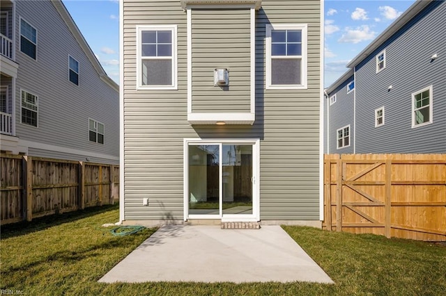 rear view of house with a yard and a patio