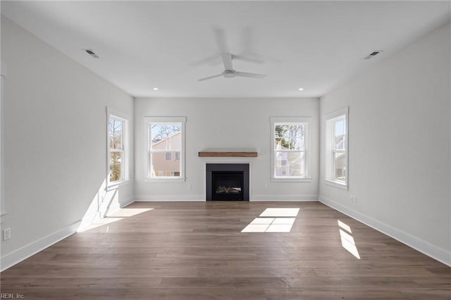 unfurnished living room featuring dark wood-type flooring and ceiling fan