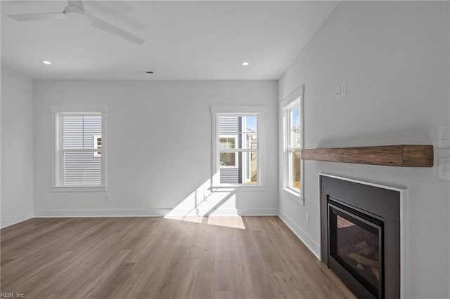 unfurnished living room with light hardwood / wood-style flooring and ceiling fan