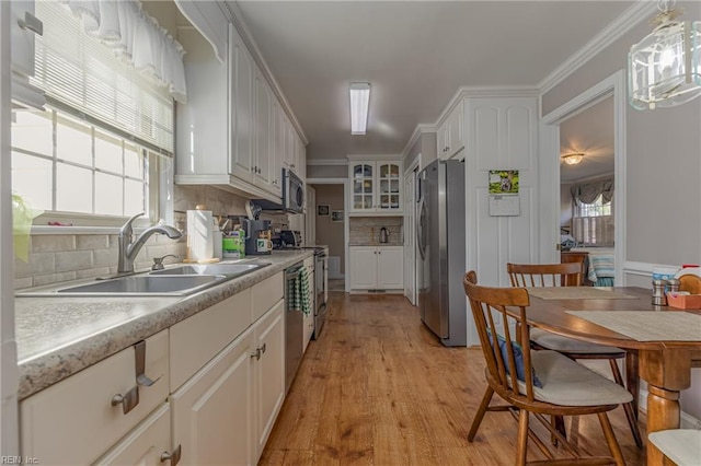 kitchen featuring white cabinetry, sink, pendant lighting, and appliances with stainless steel finishes