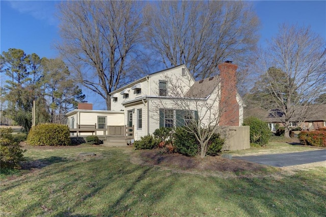 rear view of property featuring a wooden deck and a yard