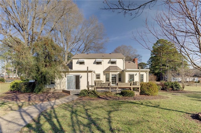 back of house featuring a wooden deck and a yard