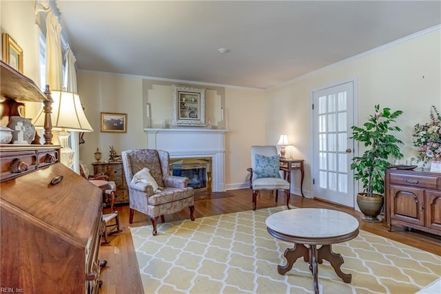 living area with hardwood / wood-style flooring and ornamental molding