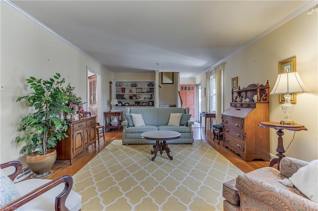 living room with crown molding and light hardwood / wood-style flooring