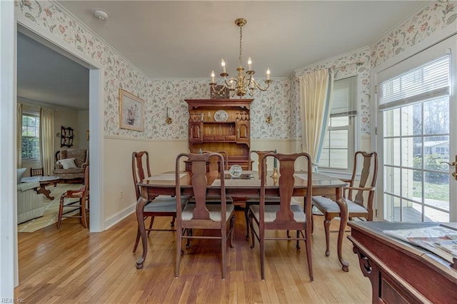 dining room featuring crown molding, an inviting chandelier, and light hardwood / wood-style floors