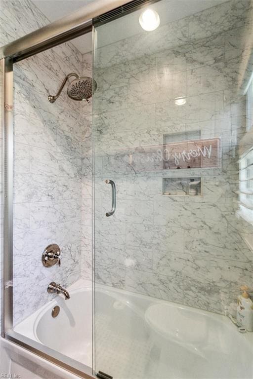 bathroom with shower / bath combination with glass door