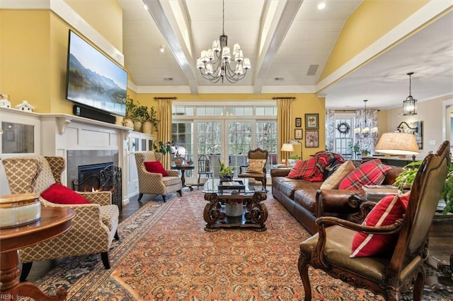 living room with a notable chandelier, hardwood / wood-style flooring, and vaulted ceiling with beams