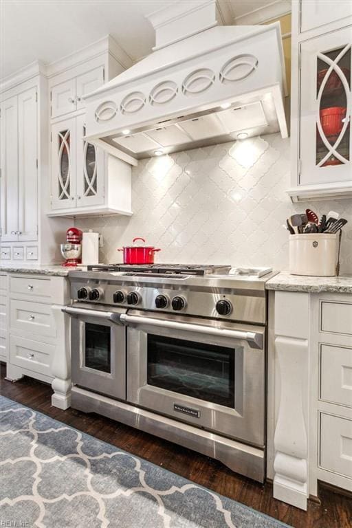 kitchen with custom exhaust hood, white cabinetry, tasteful backsplash, double oven range, and dark hardwood / wood-style flooring