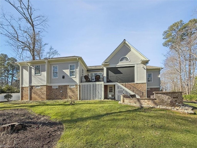 rear view of property with a yard, a deck, and a sunroom