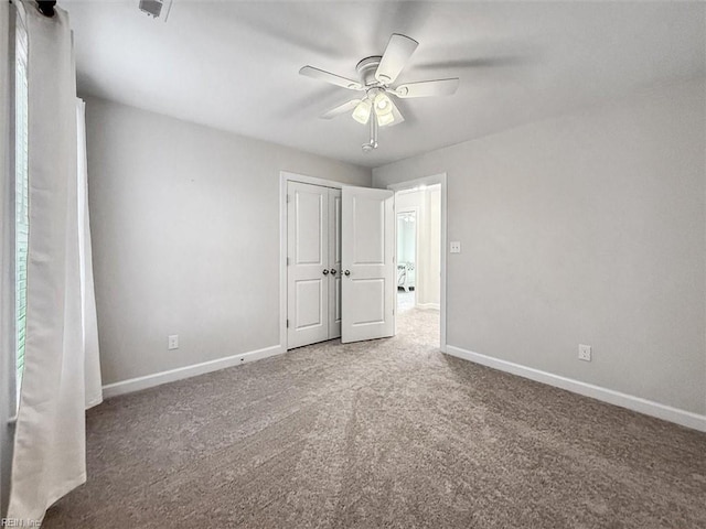 unfurnished bedroom featuring carpet floors, a closet, and ceiling fan