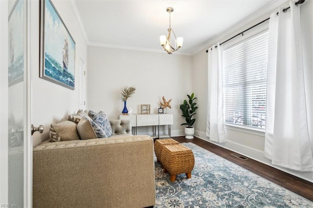 living area with an inviting chandelier, ornamental molding, and dark hardwood / wood-style flooring